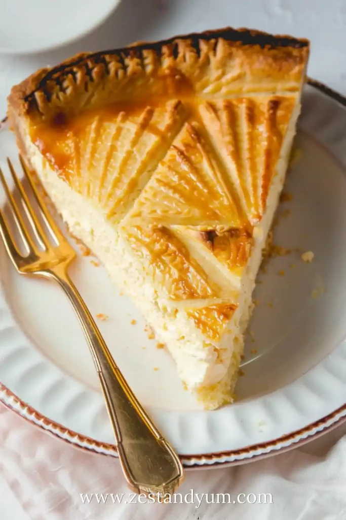 Slice of Italian Ricotta Pie with golden patterned crust and creamy filling on a white plate with a gold fork