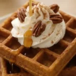Pumpkin spice waffles with whipped cream, pecans, and syrup drizzle