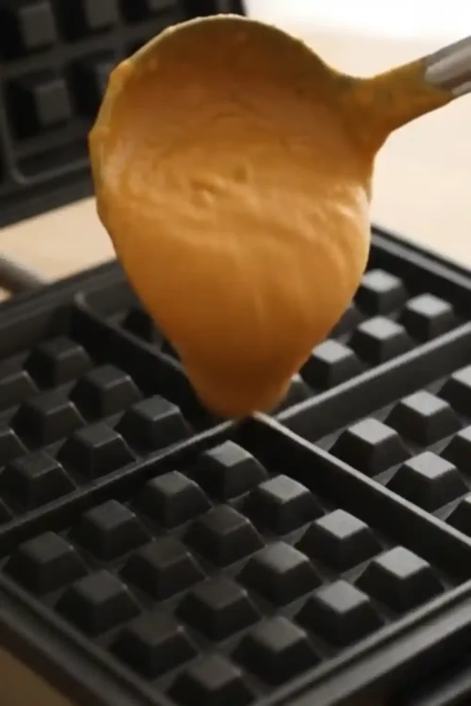 Pouring pumpkin waffle batter onto the hot iron grid