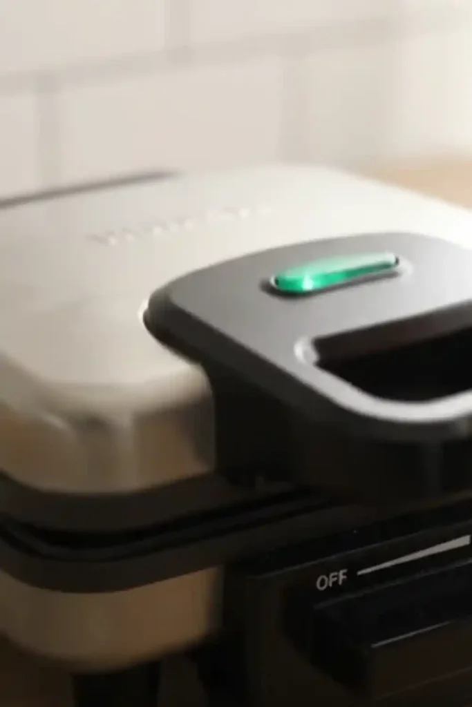 White waffle maker with green ready light on